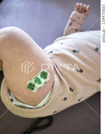 A child's leg with a brightly colored medical plaster after a vaccination. A child's leg with a brightly colored medical plaster after a vaccination. 139475683