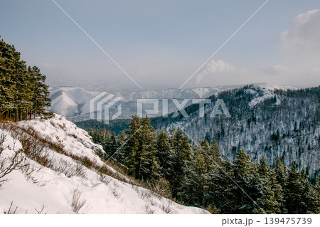Landscape of snowy Siberia Krasnoyarsk mountains, peaks range in haze winter 139475739
