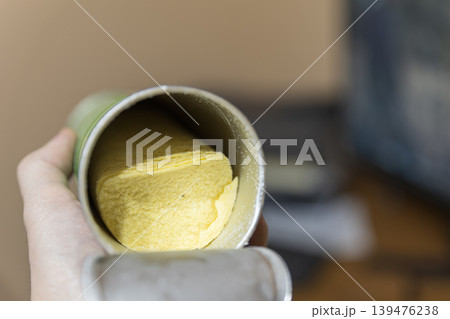 Hand holding open can of stacked potato chips, close-up view 139476238