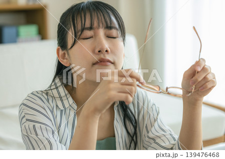 眼精疲労で眼鏡を外して休息する女性 眼精疲労で眼鏡を外して休息する女性 139476468