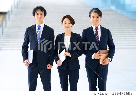 真剣な表情で並ぶ日本人ビジネスチーム3人 階段前の集合写真 真剣な表情で並ぶ日本人ビジネスチーム3人 階段前の集合写真 139476695