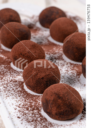 Fine chocolate truffles on white ceramic plate. Fine chocolate truffles on white ceramic plate. 139476758