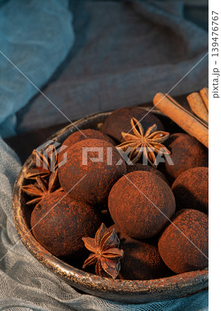Craft chocolate truffles on plate with cocoa powder and anise, cinnamon, cardamom. 139476767