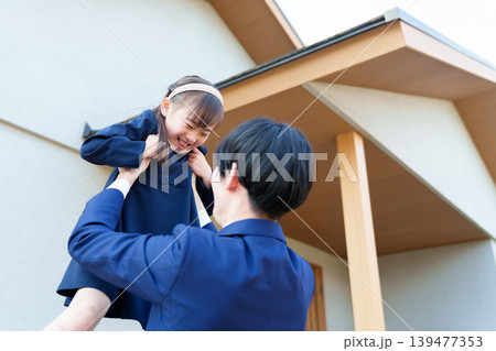 自宅の前で女の子を持ち上げるお父さん 自宅の前で女の子を持ち上げるお父さん 139477353