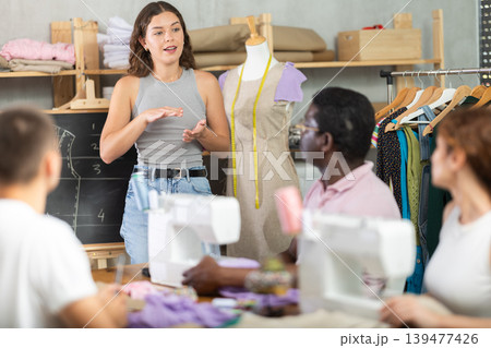 Sewing school girl teacher conducts lesson for students using mannequin 139477426