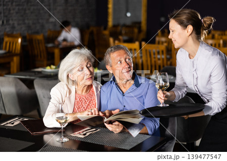 Woman waiter taking order from elderly couple in restaurant 139477547