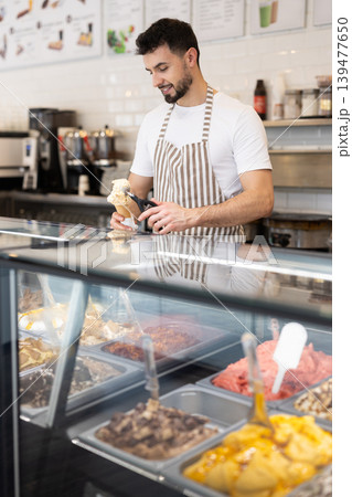 guy working in a cafe offers ice cream guy working in a cafe offers ice cream 139477650