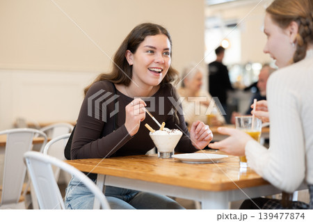 Young woman chatting with teenager in cafe 139477874