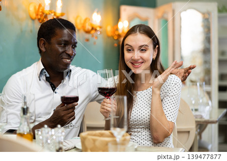 Adult couple on romantic date drinking red wine at restaurant Adult couple on romantic date drinking red wine at restaurant 139477877