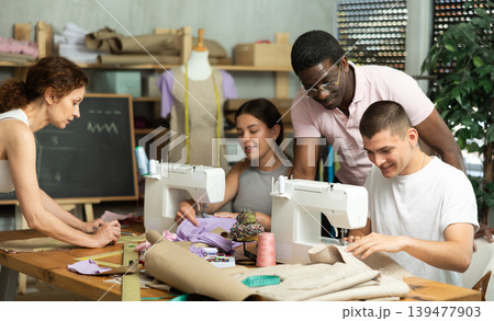 Experienced sewing instructor overseeing students in fashion course 139477903