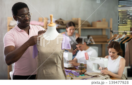 Middle-aged man working with mannequin in workshop 139477928