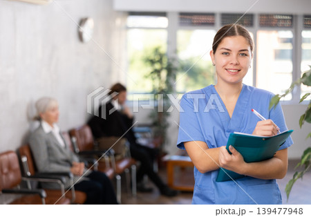 Young woman doctor makes notes in folder 139477948