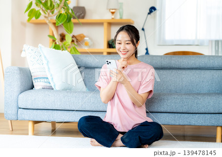 部屋でスマホを操作する若い女性 部屋でスマホを操作する若い女性 139478145