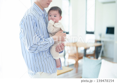 リビングで赤ちゃんをあやすお父さん リビングで赤ちゃんをあやすお父さん 139478154