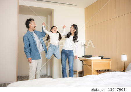 ホテルでの宿泊、家族旅行やお部屋で手を繋ぐ楽しみで大笑いでワクワクするジャンプする ホテルでの宿泊、家族旅行やお部屋で手を繋ぐ楽しみで大笑いでワクワクするジャンプする 139479014