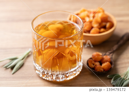 Longan juice in glass with dried longan fruit on wooden background Longan juice in glass with dried longan fruit on wooden background 139479172