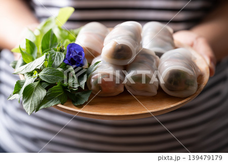 Thai Fresh Spring Rolls with Herbs and Vegetables holding by woman hand Thai Fresh Spring Rolls with Herbs and Vegetables holding by woman hand 139479179