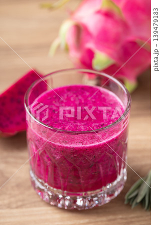 Glass of red dragon fruit smoothie on wooden background, Healthy tropical summer drink Glass of red dragon fruit smoothie on wooden background, Healthy tropical summer drink 139479183