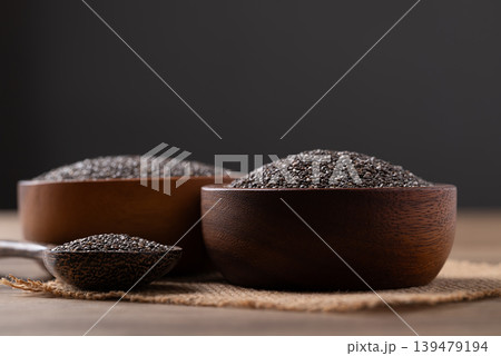 Healthy organic chia seeds in a wooden bowl and spoon on a black background Healthy organic chia seeds in a wooden bowl and spoon on a black background 139479194