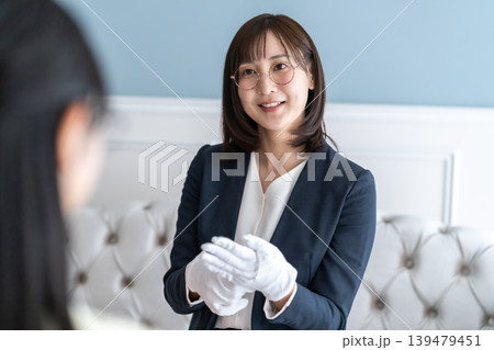タイトル候補 笑顔で丁寧に時計の査定結果を説明する女性鑑定士 139479451