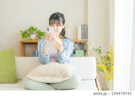 リビングでスマホを見る若い女性 リビングでスマホを見る若い女性 139479743
