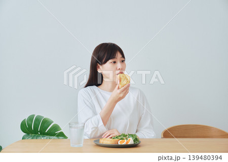 朝食を食べる笑顔の若い女性 139480394