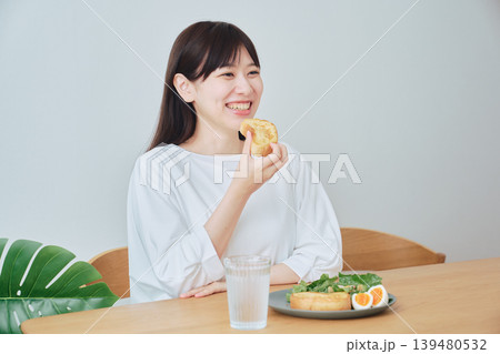 朝食を食べながら会話する若い女性 朝食を食べながら会話する若い女性 139480532