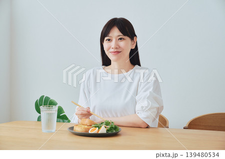朝食を食べながら会話する若い女性 朝食を食べながら会話する若い女性 139480534