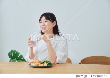 朝食をとりながら話を聞く女性 139480549