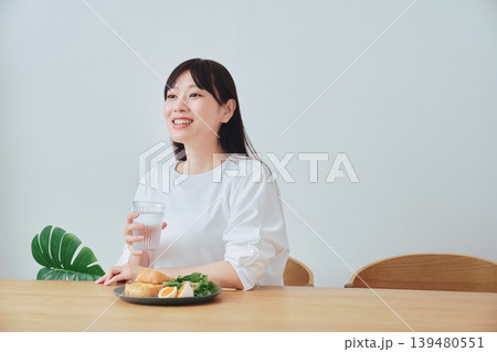 朝食をとりながら話を聞く女性 139480551