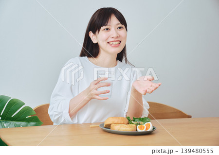 朝食を食べながら会話する若い女性 朝食を食べながら会話する若い女性 139480555