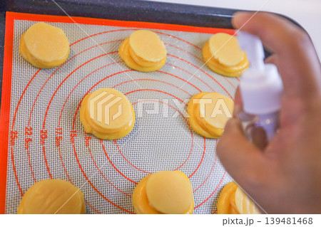 焼成前のシュー生地に霧吹きで水をかける工程 焼成前のシュー生地に霧吹きで水をかける工程 139481468