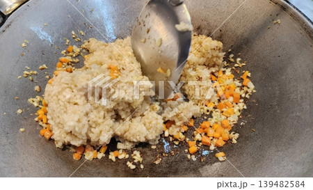 Cooking Vegetable Fried Rice in a Wok with Garlic and Carrots 139482584