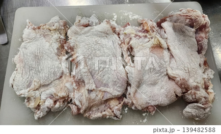 Raw Chicken Meat Dredged in Flour on Cutting Board for Cooking 139482588