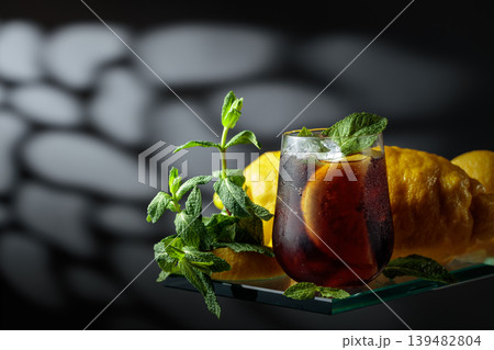 Cocktail with lemon wedges, ice and mint in misted glass. Cocktail with lemon wedges, ice and mint in misted glass. 139482804