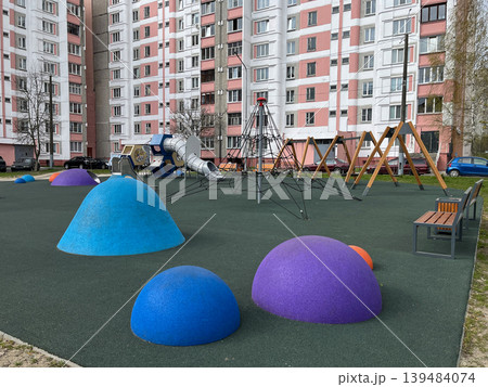 Modern colorful playground in residential courtyard with climbing net Modern colorful playground in residential courtyard with climbing net 139484074