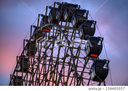Ferris wheel cabins at dusk against pink and blue sky 139485057