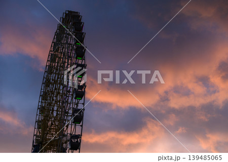 Ferris wheel silhouette at sunset with colorful clouds Ferris wheel silhouette at sunset with colorful clouds 139485065