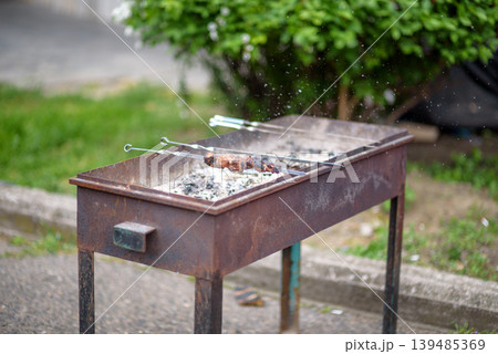 Rustic charcoal barbecue grill with skewers outdoors Rustic charcoal barbecue grill with skewers outdoors 139485369