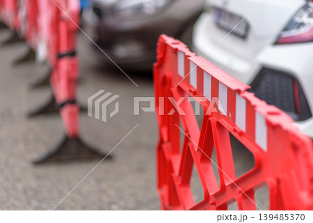 Red road barrier with reflective stripes on city street 139485370