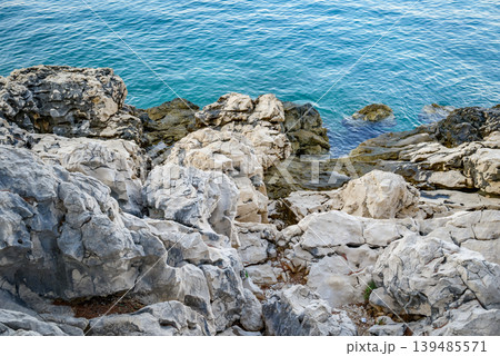 Rocky shoreline with clear blue sea water Rocky shoreline with clear blue sea water 139485571