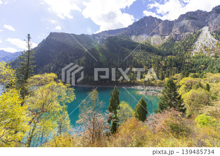 Beautiful view of the Long Lake among colorful fall woods and mountains in Jiuzhai Valley National Park in China. Beautiful view of the Long Lake among colorful fall woods and mountains in Jiuzhai Valley National Park in China. 139485734