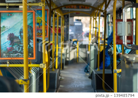 City bus interior with yellow handrails, rows of seats, and an advertising poster, in Beijing, China City bus interior with yellow handrails, rows of seats, and an advertising poster, in Beijing, China 139485794