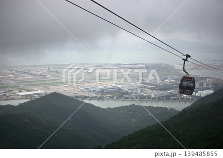 Cable car gondola of Ngong Ping 360, suspended on a ropeway in dense fog, on Lantau Island in SAR Hong Kong, China Cable car gondola of Ngong Ping 360, suspended on a ropeway in dense fog, on Lantau Island in SAR Hong Kong, China 139485855