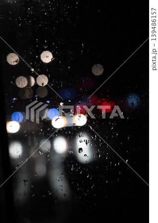 Rain on Window at Night with Blurred City Lights. Moody Urban Background. Raindrops Rain on Window at Night with Blurred City Lights. Moody Urban Background. Raindrops 139486157