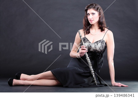 girl and flute on a black background girl and flute on a black background 139486341