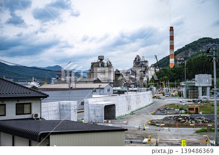 新築の防潮堤と建設中の施設が並ぶ被災地の復興風景と工場 新築の防潮堤と建設中の施設が並ぶ被災地の復興風景と工場 139486369