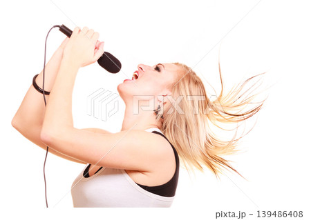 Blonde woman singing to microphone, profile view Blonde woman singing to microphone, profile view 139486408