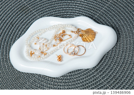 A selection of jewelry is placed on a white dish.  139486906
