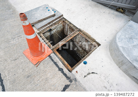 Cautionary hazard of open manhole drain hole with safety cone Cautionary hazard of open manhole drain hole with safety cone 139487272